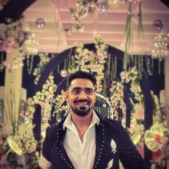 A close-up shot from a grand wedding event. The beautiful floral decor in the background complemented my embellished jacket perfectly.