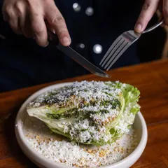 My Manor Caesar salad is a classic for a reason. I use crisp iceberg lettuce, buttery croutons, and a generous amount of shaved parmesan, all tossed in a creamy Caesar dressing. It's a salad so good, it might just steal the show.