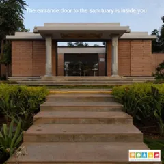 The entrance to a sanctuary space, designed to evoke a sense of peace and introspection. The structure uses natural materials like rammed earth walls and stone pillars to create a grounded and timeless feel.