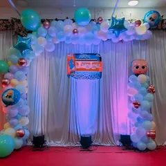 A Boss Baby themed balloon arch for a naming ceremony, with blue uplighting creating a special ambiance.