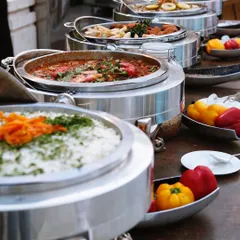 A beautiful lineup of my main course dishes in stylish silver chafing dishes. I ensure my buffet spreads are colorful, abundant, and inviting for every guest.