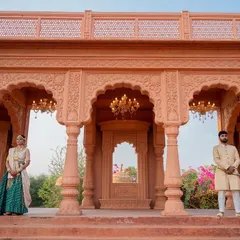 A powerful composition showing the couple standing apart but connected by the grand architecture. This shot emphasizes both individuality and partnership within a royal pre-wedding theme.