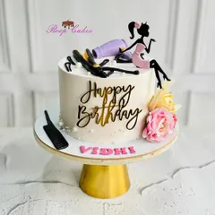 A chic and glamorous birthday cake for a hairstylist. The design features edible salon tools like a hairdryer and straightener, along with a stylish silhouette topper.