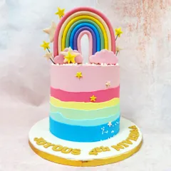 Our Pink Rainbow Cake features a beautiful pastel rainbow topper, fluffy clouds, and a colorful ombre effect on the cake itself.