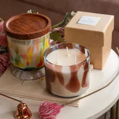 This shot showcases two of my most popular artistic candles. The one on the left features a rich wooden lid, while the other has an open, three-wick design. Both are made with 100% natural soy wax for a clean, sustainable burn.