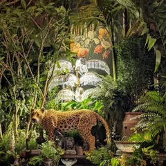 A stunning composition from the Sabyasachi event, where a leopard statue is nestled within a jungle of palms and Frangipani trees. The scene is illuminated by crystal palm tree lamps, blending our greenery with the event's luxurious design elements.