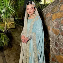 A full-length view of this stunning Nikah bride. The powder blue and gold outfit is absolutely breathtaking, and her makeup is kept elegant and timeless to match.