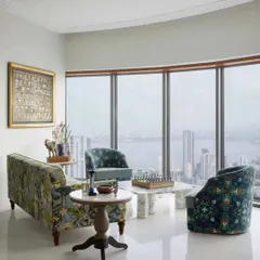 For this Mumbai high-rise residence, the living room was designed to frame the magnificent sea view. I used a mix of custom-upholstered furniture in rich patterns and a large-scale Pichwai painting to create a space that is sophisticated, comfortable, and deeply connected to its surroundings.
