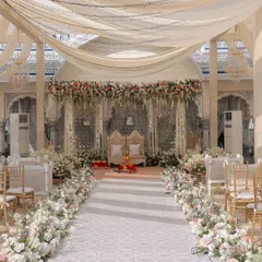 The aisle for this pastel wedding was designed to be a serene and soft walkway. Lined with lush English garden-style florals in blush and peach, it created a gentle, romantic path leading to the thikri-work mandap.