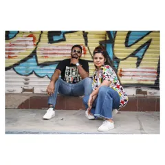An urban portrait with a bit of edge. The couple poses against a graffiti wall, their modern style and confident poses creating a cool, fashionable look for their pre-wedding shoot.