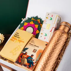 This hamper is a celebration of modern wellness and Indian tradition. It features a hammered copper bottle for health benefits, alongside The Daily Nut Co.'s health mix and paan shots, plus a beautiful diya for the festive touch.