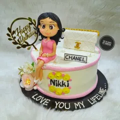 A cake as elegant and timeless as the woman it was for. This design features a custom figurine of the birthday girl sitting next to her favorite Chanel bag, surrounded by delicate flowers.