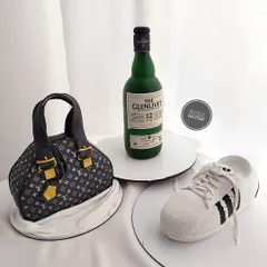 A showcase of our structure cakes. This collection features a realistic Louis Vuitton bag, a Glenlivet liquor bottle, and Adidas sneakers, all carved from cake.