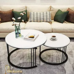 A minimalist nesting table set with clean white tops and slender black metal bases. The design allows the smaller table to tuck neatly under the larger one, making it a smart solution for compact living areas.