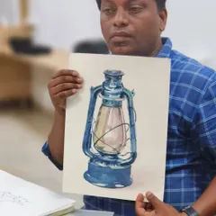 Our instructor, Sushil, displays a watercolor painting of a lantern. This piece is an example of a finished artwork that begins with fundamental sketching and observation skills.