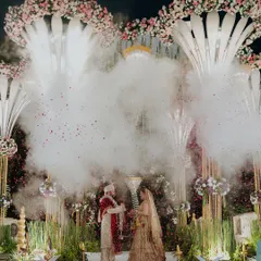 A cinematic shot of the couple's varmala, enveloped in a cloud of smoke. These special effects are timed perfectly to create dramatic and unforgettable photographs of your key moments.