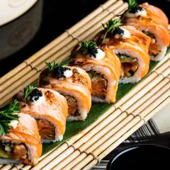 The art of sushi is a delicate dance. Here, our chefs meticulously prepare seared salmon rolls, topped with truffle mayo and caviar, showcasing a commitment to fresh ingredients and refined Japanese techniques.