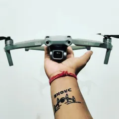 My passion for this work goes deep. Here I am holding my DJI Air 2S, with a tattoo that shows my love for being a drone pilot.