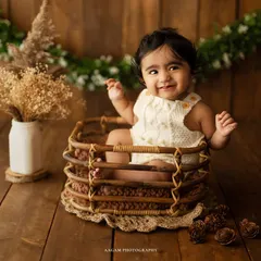 A moment of pure joy. This little one is having so much fun in this rustic basket setup, surrounded by natural props and greenery.