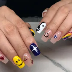 Let your nails show your fun side. This set of square nail extensions features a different quirky design on each finger, including a smiley face, cherries, a yin-yang symbol, and a rainbow.