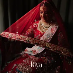 A beautiful portrait of the bride, Riya, under her veil. This classic shot captures her serene expression and the intricate details of her bridal look.