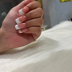 A close-up of a flawless French manicure on square-tipped extensions. The lines are sharp, the finish is glossy, and the look is pure elegance.