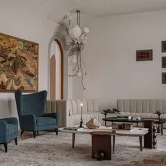 The formal living room at Rehethaan is a study in sophisticated comfort. We used a mix of custom sofas, elegant wingback chairs, and sculptural coffee tables, all set under a ceiling with intricate gypsum embroidery and bespoke chandeliers.