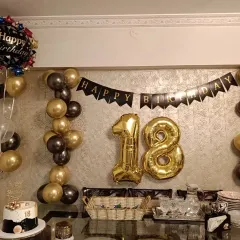 Here is a classic and elegant 18th birthday setup. I used a black and gold color scheme with number foil balloons, a "Happy Birthday" banner, and coordinated balloon columns to create a sophisticated look for this important milestone.