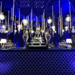 We transformed this space into a mystical Sufi night. The bar features a deep blue color palette, intricate latticework, and dozens of hanging lanterns and traditional brass surahis to create a magical, ambient glow.