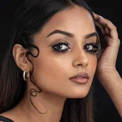 This look is all about drama and precision. The student has created a bold, graphic eye with embellished lashes and a sculpted, wet-look hairstyle, perfect for a high-fashion editorial.