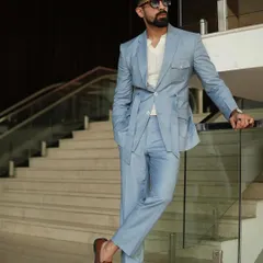 Our design philosophy blends classic tailoring with modern functionality. This custom ice-blue suit features a unique belted jacket and safari-style pockets, offering a contemporary yet sophisticated option that stands apart from traditional suiting.