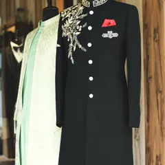Another view from the studio, focusing on the black sherwani with its intricate gold floral embroidery. This piece is a favorite for grooms looking for a powerful and regal reception look.