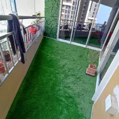 A high-angle view of a completed balcony project featuring an artificial grass floor and a green wall. This setup is perfect for city living, providing a clean and green space without the need for maintenance.