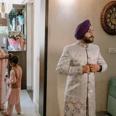 A candid moment of the groom getting ready at home, with family life happening around him. This documentary style captures the real, unscripted start to the wedding day.