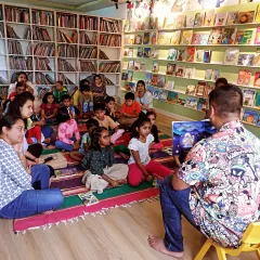 A wide shot of our storytelling session, showing a full house of kids and parents completely absorbed in the tale. The library is filled with books, creating the perfect atmosphere for literary magic.