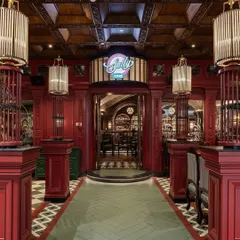Our platform showcases the best of commercial design, like this bold entrance to 'Sally by 1522' from Studio Camarada. The design reimagines a classic British pub with dramatic red paneling and bespoke lighting, creating an immersive experience for visitors.