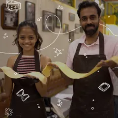 There's nothing quite like the pride of making pasta from scratch. Here, two of our participants proudly display their freshly rolled pasta sheet before turning it into a delicious meal.