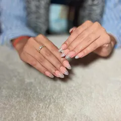 A beautiful set of almond-shaped extensions with a nude base and a sparkling silver glitter fade from the tips.