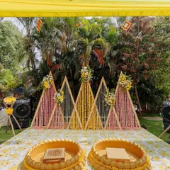A closer look at a custom Haldi ceremony stage we designed. The setup features geometric wooden backdrops adorned with marigold and tuberose strings, perfectly complementing the traditional yellow theme.