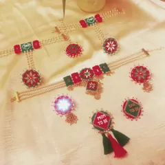 This is a complete baby shower jewelry set I created for a client. It includes a 'Mom to be' and 'Dad to be' brooch, necklace, earrings, and mathapatti, all handcrafted with fabric and pearls in a festive red and green theme.