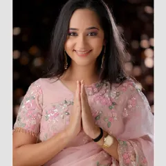 A welcoming and graceful pose in a delicate pink saree. This image radiates warmth and is perfect for festive or family-oriented themes.