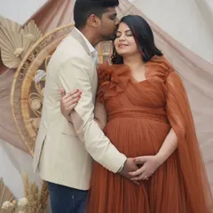 A tender moment between the parents-to-be. Her makeup is soft and romantic, with a focus on glowing skin and defined eyes, perfectly matching the bohemian-themed shoot.
