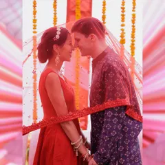 An intimate portrait of the couple under the bride's red veil. This shot symbolizes their union, bringing them together in a shared space of love and tradition.