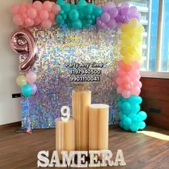 A 9th birthday setup featuring a silver shimmer wall, colorful pastel balloons, and light-up marquee letters, all available for rent.