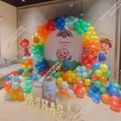 A Cocomelon themed balloon ring decoration, perfect for home celebrations. The setup includes character cutouts and marquee letters for the child's name.