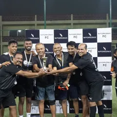The winning corporate team celebrates together, holding their trophy high after a competitive tournament.