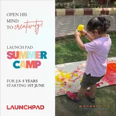Creativity knows no limits here. A young camper uses a water gun to create a large-scale splatter painting, a fantastic activity for sensory exploration and uninhibited artistic expression.