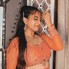 A soft and candid moment captured during the photoshoot. This image highlights the beautiful jewelry and the delicate, traditional feel of the look.