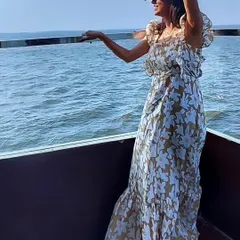 Enjoying the sea breeze in a floral print maxi dress. The ruffled sleeves and tiered skirt add a touch of romance to this perfect vacation outfit.
