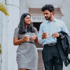 A candid shot of a couple walking and chatting over coffee, reflecting a modern and relatable lifestyle pre-wedding theme.
